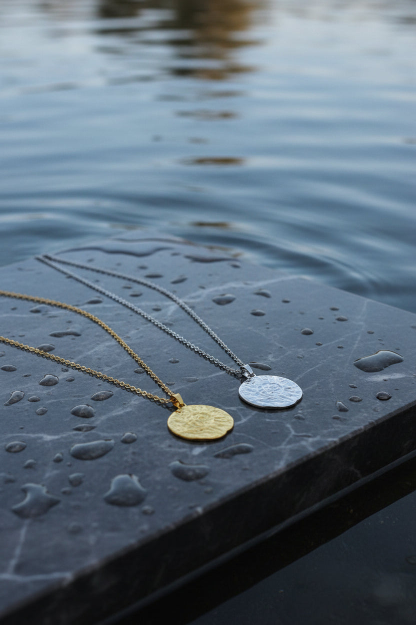 Two necklaces with circular pendants on a light gray background