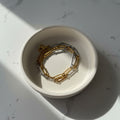 Gold and silver chain necklace on a light gray background